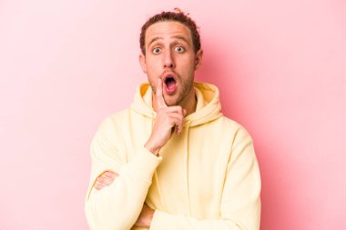 Pembe arka planda soyutlanmış genç beyaz bir adam. Harika bir fikri var, yaratıcılık kavramı..