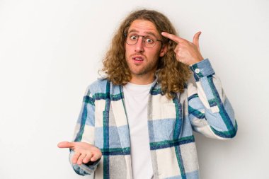 Beyaz arka planda izole edilmiş genç beyaz bir adam elinde bir ürün tutuyor ve.