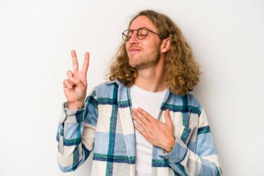 Beyaz arka planda izole edilmiş genç beyaz adam yemin ediyor, elini göğsüne koyuyor..