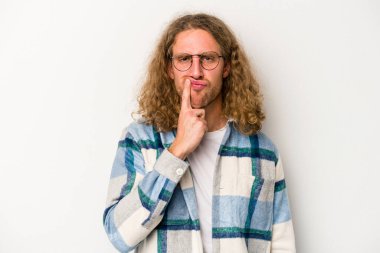 Beyaz arka planda soyutlanmış genç beyaz bir adam düşünüyor ve yukarı bakıyor, yansıtıyor, düşünüyor, hayal kuruyor..