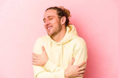 Genç beyaz adam pembe arka planda izole edilmiş gülüyor ve eğleniyor..