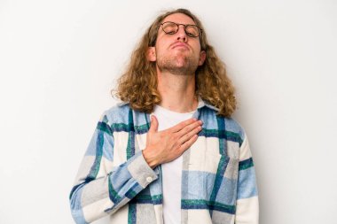 Beyaz arka planda izole edilmiş genç beyaz adam yemin ediyor, elini göğsüne koyuyor..