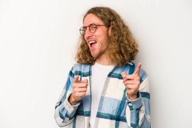 Beyaz arka planda izole edilmiş genç beyaz adam parmaklarıyla ön tarafı işaret ediyor..
