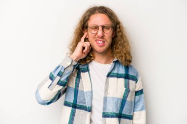 Beyaz arka planda izole edilmiş genç beyaz bir adam parmaklarıyla kulaklarını kapatıyor, gürültülü bir ortam yüzünden stresli ve çaresiz..