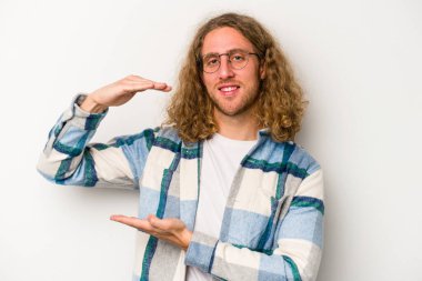 Beyaz arka planda izole edilmiş beyaz bir adam iki eliyle bir şey tutuyor..