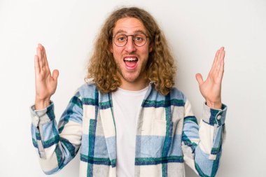 Beyaz arka planda izole genç beyaz adam hoş bir sürpriz alıyor, heyecanlı ve el kaldırıyor..