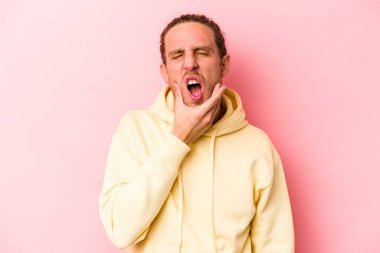 Pembe arka planda izole genç beyaz adam güçlü bir diş ağrısı, azıdişi ağrısı var..