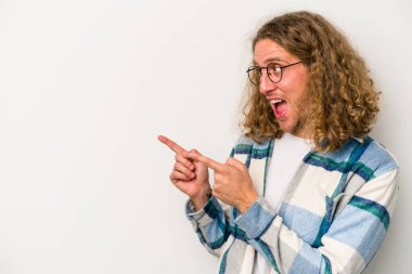 Beyaz arka planda izole genç beyaz adam parmak uzakta, gülüyor ve kaygısız.