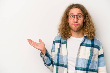 Beyaz arka planda izole edilmiş genç beyaz bir adam bir palmiye üzerinde fotokopi alanı gösteriyor ve belinde başka bir el tutuyor..