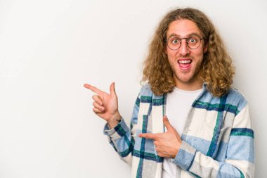 Beyaz arka planda izole edilmiş genç beyaz bir adam işaret parmağıyla işaret ettiği için heyecanlı..