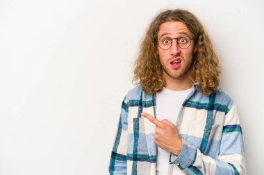Beyaz arka planda izole edilmiş genç beyaz adam yan tarafı işaret ediyor