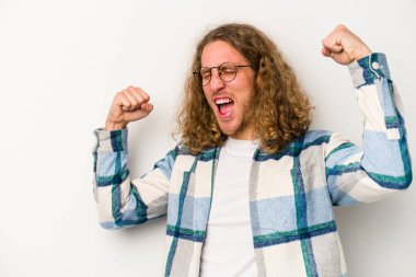 Beyaz arka planda izole edilmiş genç beyaz bir adam zaferden sonra yumruğunu kaldırıyor, kazanan konsept.