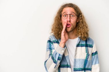 Beyaz arka planda izole edilmiş genç beyaz bir adam gizli bir sıcak fren haberi veriyor ve yana bakıyor.