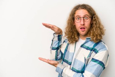 Beyaz arka planda izole edilmiş genç beyaz adam elleri arasında bir kopya alanı tutarken şok ve hayrete düştü..