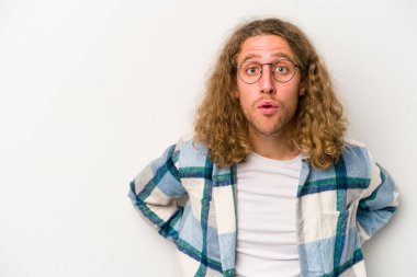 Beyaz arka planda izole edilmiş genç beyaz adam gördüğü bir şey yüzünden şoka uğruyor..