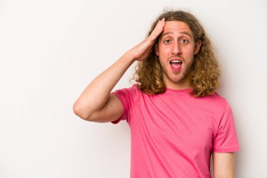 Beyaz arka planda izole genç beyaz adam yüksek sesle bağırıyor, gözleri açık ve elleri gergin tutuyor..