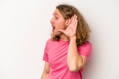 Beyaz arka planda izole edilmiş genç beyaz adam bir dedikoduyu dinlemeye çalışıyor..