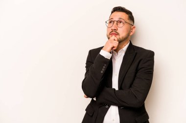 İspanyol iş adamı beyaz arka planda izole edilmiş şüpheli ve şüpheci bir ifadeyle yana bakıyor..