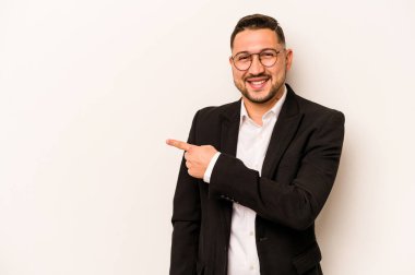 Beyaz arka planda izole edilmiş İspanyol bir adam gülümsüyor ve boş alanda bir şeyler gösteriyor..