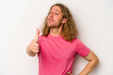 Beyaz arka planda izole edilmiş genç beyaz bir adam selamlama jesti olarak kameraya elini uzatıyor..