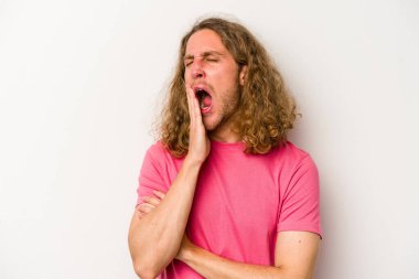 Beyaz arka planda izole edilmiş genç beyaz adam esniyor. Ağzı eliyle kapatan yorgun bir hareket sergiliyor..