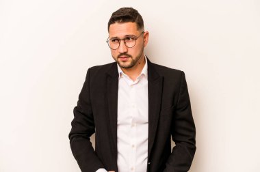 Beyaz arka planda izole edilmiş İspanyol bir adam kafası karışmış, şüpheli ve güvensiz hissediyor..