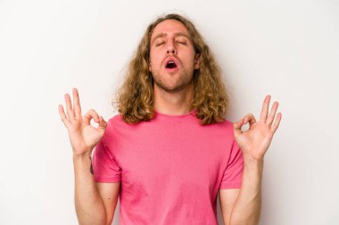 Beyaz arka planda izole edilmiş genç beyaz adam yoğun bir günün ardından rahatlıyor. Yoga yapıyor..