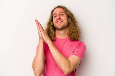 Beyaz arka planda izole olmuş genç beyaz bir adam enerjik ve rahat hissediyor, ellerini ovuşturuyor..