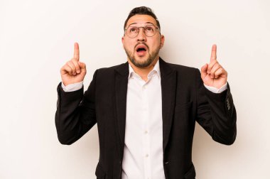 Beyaz arka planda izole edilmiş İspanyol bir adam ağzı açık bir şekilde üst tarafı işaret ediyor..