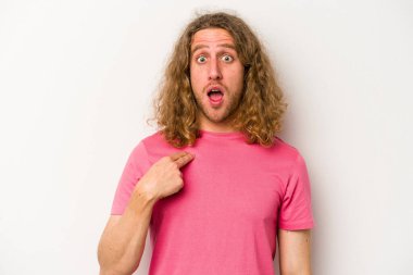 Beyaz arka planda izole edilmiş genç beyaz bir adam parmağını göstererek şaşırdı, geniş bir gülümsemeyle..