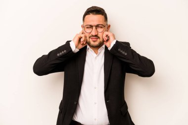 Beyaz arka planda izole edilmiş İspanyol bir adam kulakları elleriyle kapatıyor..