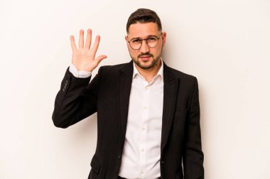 Beyaz arka planda izole edilmiş İspanyol bir adam gülümseyerek beş numarayı parmaklarıyla gösteriyor..