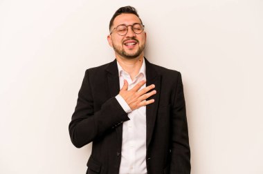 Beyaz arka planda izole edilmiş İspanyol bir adam yüksek sesle gülüyor ve elini göğsüne koyuyor..