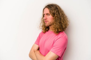 Beyaz arka planda izole edilmiş genç beyaz bir adam şüpheli, belirsiz, seni muayene ediyor..