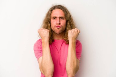 Beyaz arka planda izole edilmiş genç beyaz bir adam yumruğunu kameraya gösteriyor, agresif bir yüz ifadesi..