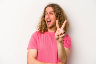 Beyaz arka planda izole edilmiş genç beyaz adam iki numarayı parmaklarıyla gösteriyor..
