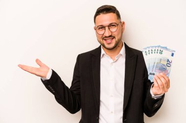 Beyaz arkaplanda banknotlar tutan İspanyol bir adam bir avuç içinde fotokopi alanı ve belinde bir el daha gösteriyor..