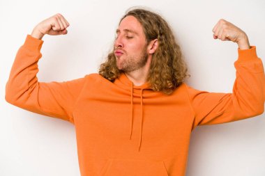 Beyaz arka planda izole edilmiş genç beyaz bir adam güçlü bir hareket gösteriyor, kollarıyla, kadınsı gücün sembolü.