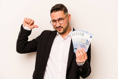 Beyaz arka planda para tutan İspanyol bir adam gururlu ve kendinden emin, örnek olarak..