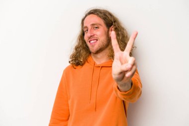 Beyaz arka planda izole edilmiş genç beyaz bir adam neşeli ve kaygısız parmakları olan bir barış sembolü gösteriyor..