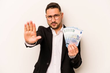Beyaz arka planda izole edilmiş banknotları tutan İspanyol bir adam elini uzatmış, dur işareti göstererek seni engelliyor..