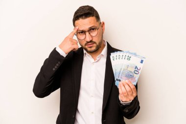 Beyaz arka planda izole edilmiş banknotları tutan İspanyol bir adam işaret parmağıyla yaptığı hayal kırıklığı jestini gösteriyor..