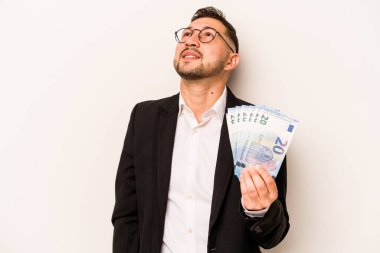 Hispanik bir iş adamı beyaz arka planda izole edilmiş banknotlar tutuyor hedeflere ve amaçlara ulaşmayı hayal ediyor.