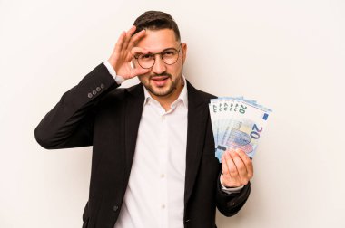 Hispanik adamın elinde banknotlar var. Beyaz arka planda izole edilmiş. Heyecanlı..
