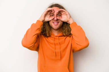 Beyaz arka planda izole edilmiş genç beyaz bir adam gözlerinde sorun olmadığını gösteriyor.