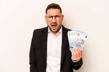 Beyaz arka planda izole edilmiş banknotları tutan İspanyol bir adam çok sinirli ve agresif bağırıyor..