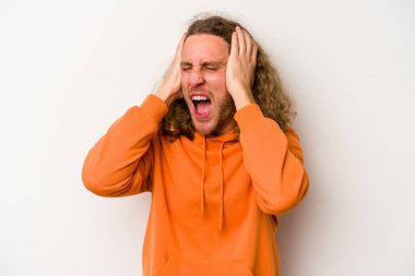 Beyaz arka planda izole edilmiş genç beyaz bir adam kulakları kulaklarıyla kapatıyor ve çok ses duymamaya çalışıyor..