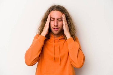 Beyaz arka planda izole olmuş genç beyaz bir adam başı ağrıyor, yüzüne dokunuyor..
