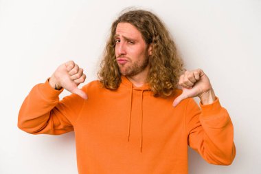 Beyaz arka planda izole edilmiş genç beyaz adam baş parmağını aşağı gösteriyor, hayal kırıklığı konsepti..