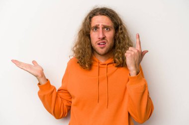 Beyaz arka planda izole edilmiş genç beyaz bir adam elinde bir ürün tutuyor ve.